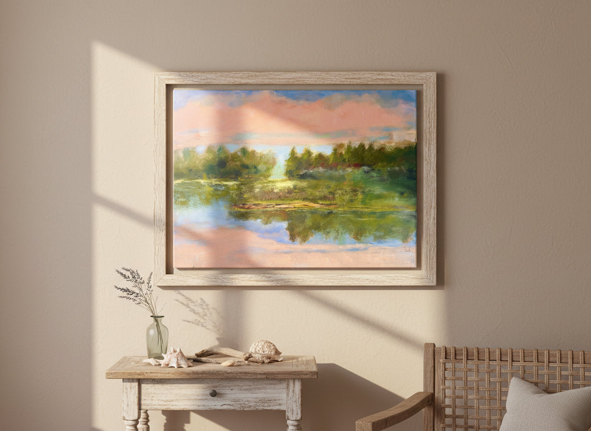 Framed impressionist painting of a calm lake with distant trees and soft pink light reflecting on still water on a wall