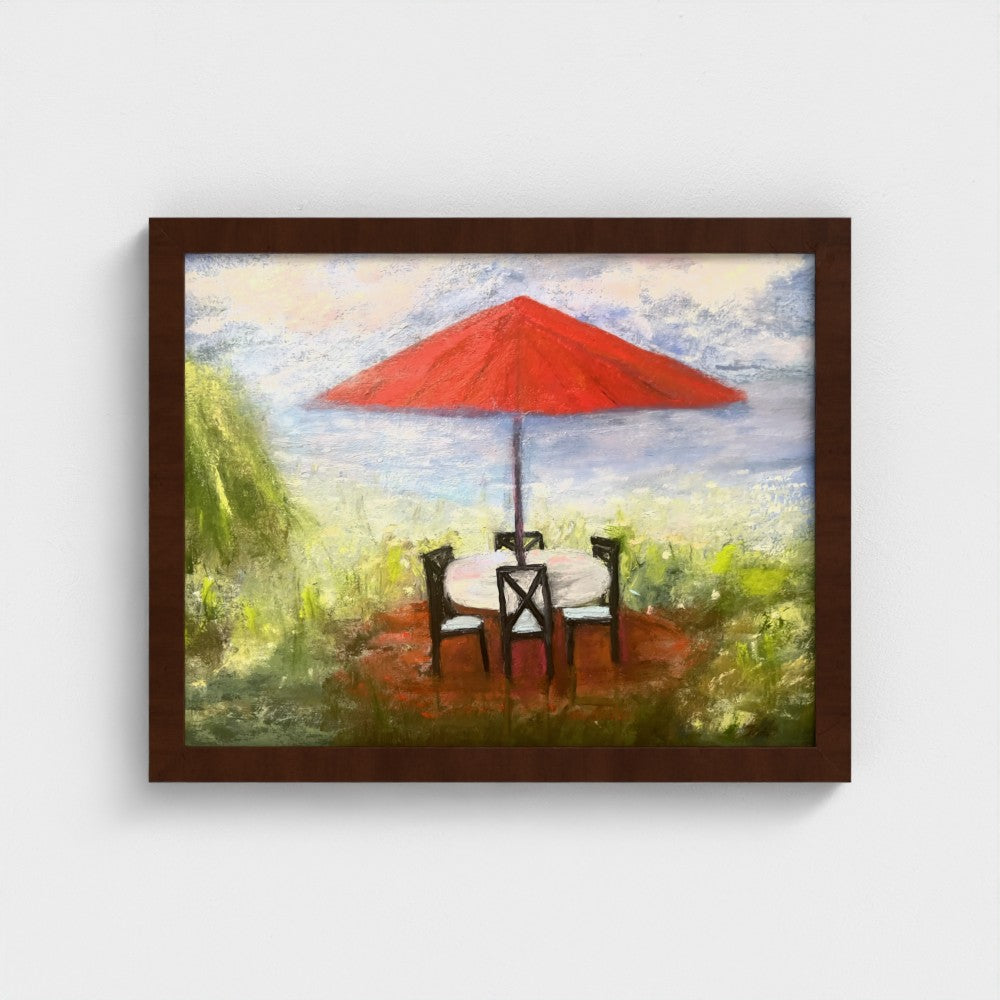 Framed impressionistic painting of an outdoor setting with a red umbrella, table, and chairs.